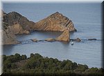 Een nietig bootje vaart langs de Cabo de la Nau in Jvea