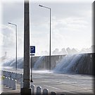 Het water gutst over de zeewering de pier op