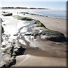 Een rotsarm bereikt bijna de zee, op het strand van Baleal